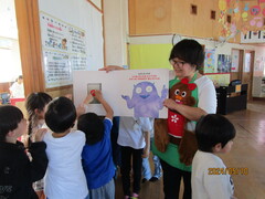 本に書かれたボタンを押す子どもたち