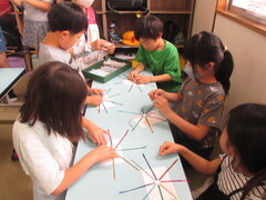 キラキラテープを丸シールに貼っている子どもたち