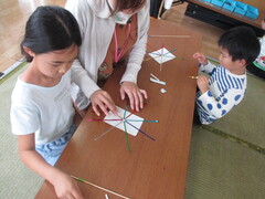 キラキラテープを丸シールに貼っている子ども