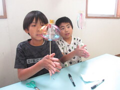 完成したくるくるレインボーを回して楽しむ男の子2人