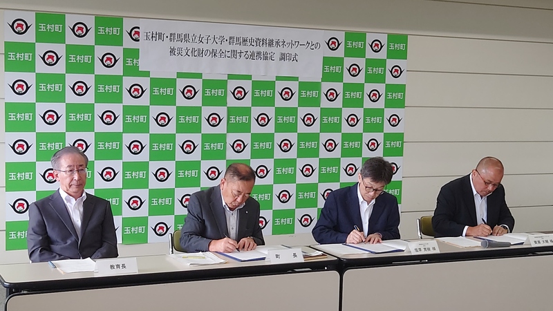 協定書にサインする石川町長