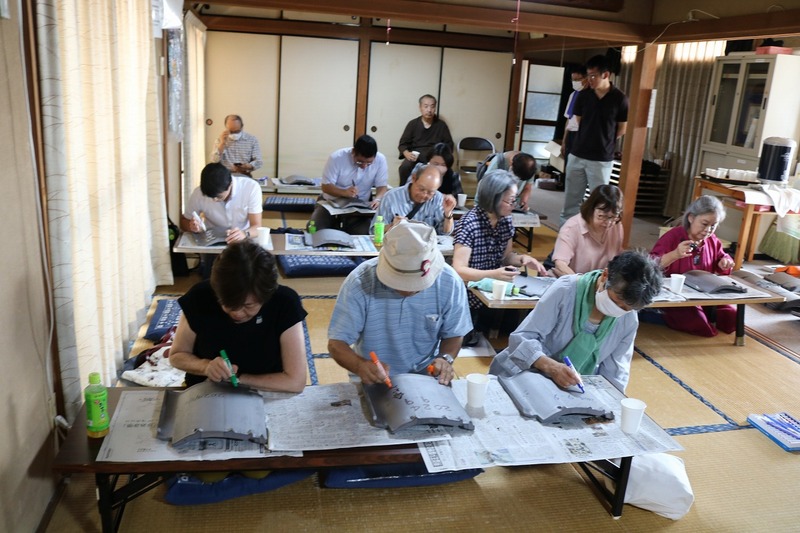 瓦にメッセージを記入する参加者