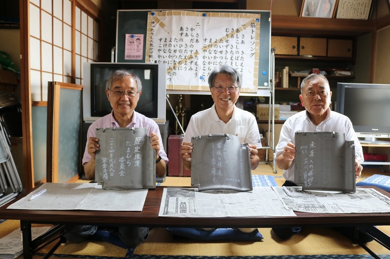 瓦にメッセージを記入した石川町長