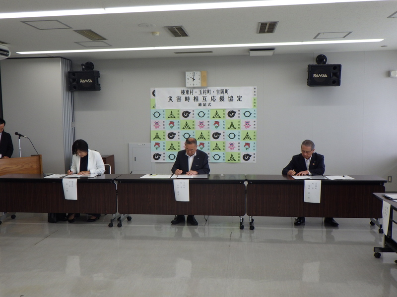 協定書にサインする石川町長