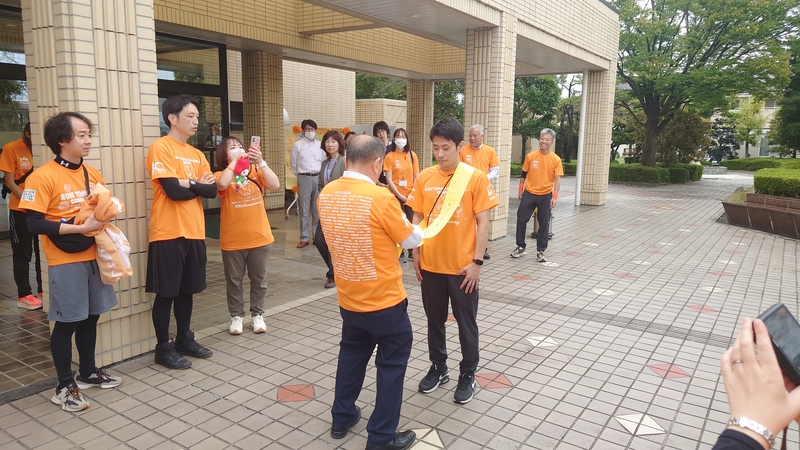 ランナーにタスキを掛ける石川町長