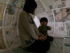 親子で新聞紙ドームに入っているところ