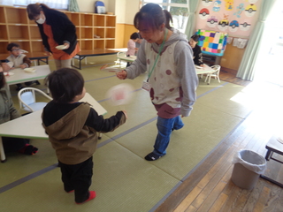 男児がでんでん太鼓を回しているところ