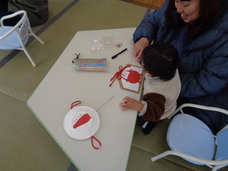 男児が絵馬を作っているところ