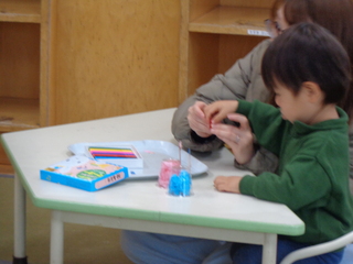 男児が親子でおひなさまを作っているところ
