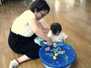 親子で金魚すくいをしているところ