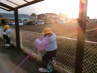 一輪車検定6級　片手でフェンスにつかまってこいているところ