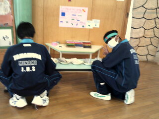 男児たちが折り紙をしているところ