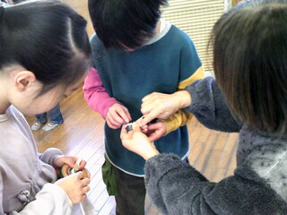 子どもたちがベーゴマを教えてもらっているところ
