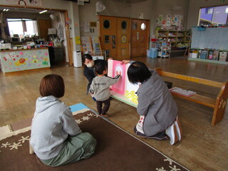 大型絵本を見ながらドアをトントンしているところ